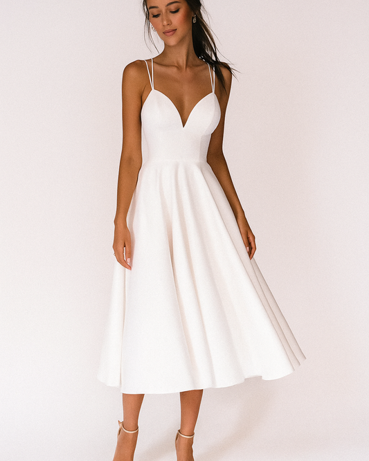 Front view of a woman wearing the white elegant midi dress, showcasing the V-neckline and full A-line skirt.