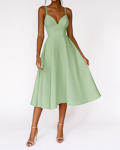 Full-length shot of the white elegant midi dress styled with simple accessories, ideal for a wedding guest.