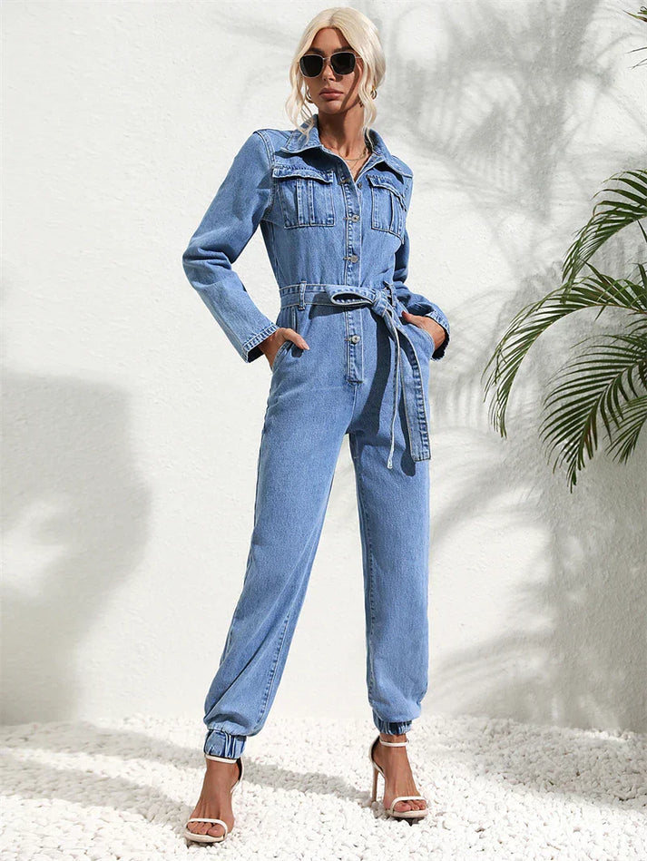 Close-up of the belted waist and button details on the front of the casual denim jumpsuit.