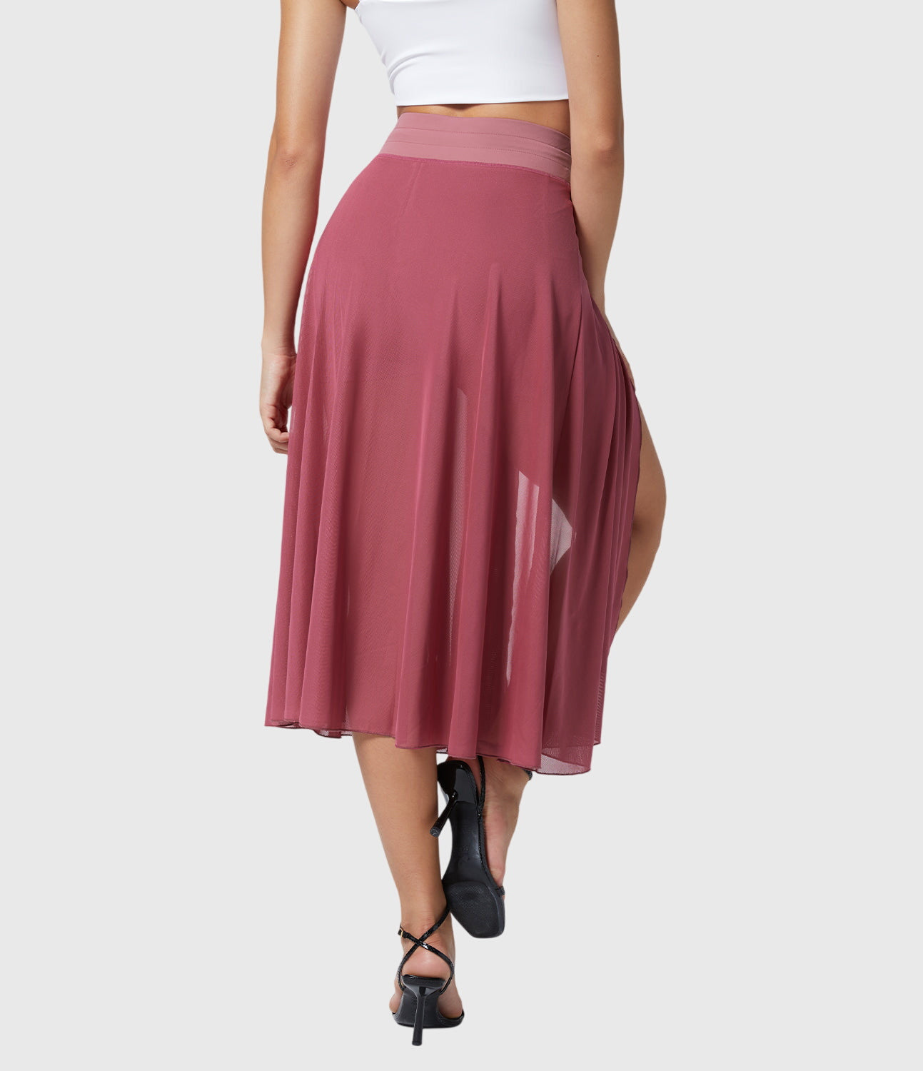 The orange transformable fluid skirt displayed on a hanger, showing its wrinkle-resistant properties and easy care.