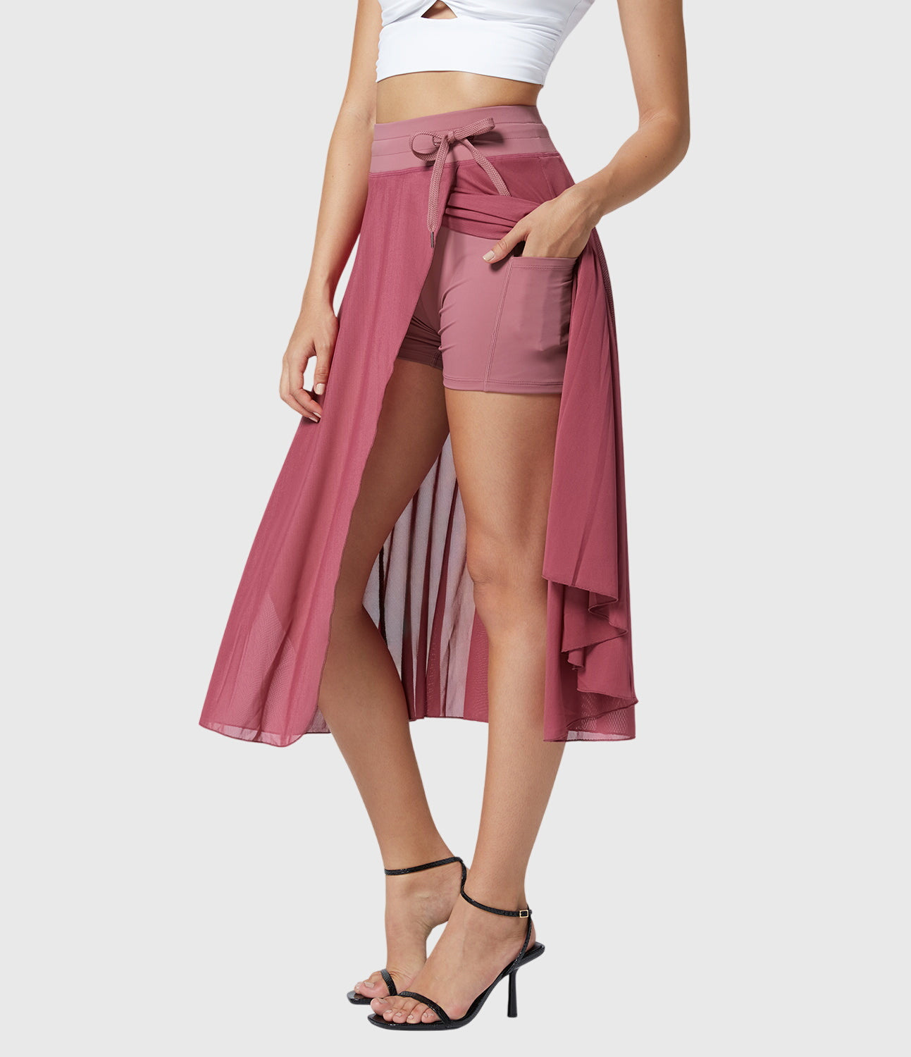 Model in a playful pose wearing the grey transformable fluid skirt, capturing the fun and energetic vibe.