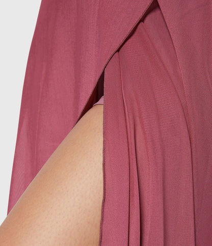 Frontal view of the turquoise transformable fluid skirt, with hands adjusting the waist tie for a personalized fit.