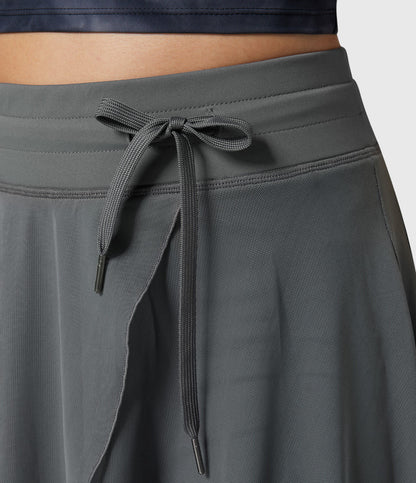 Model in a relaxed pose wearing the violet transformable fluid skirt, ideal for comfort and style on the go.