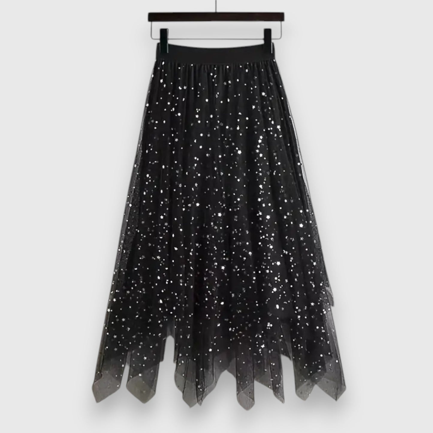Side view of a woman gracefully walking in the black Valentina tulle midi skirt, highlighting its fluid movement and midi length.