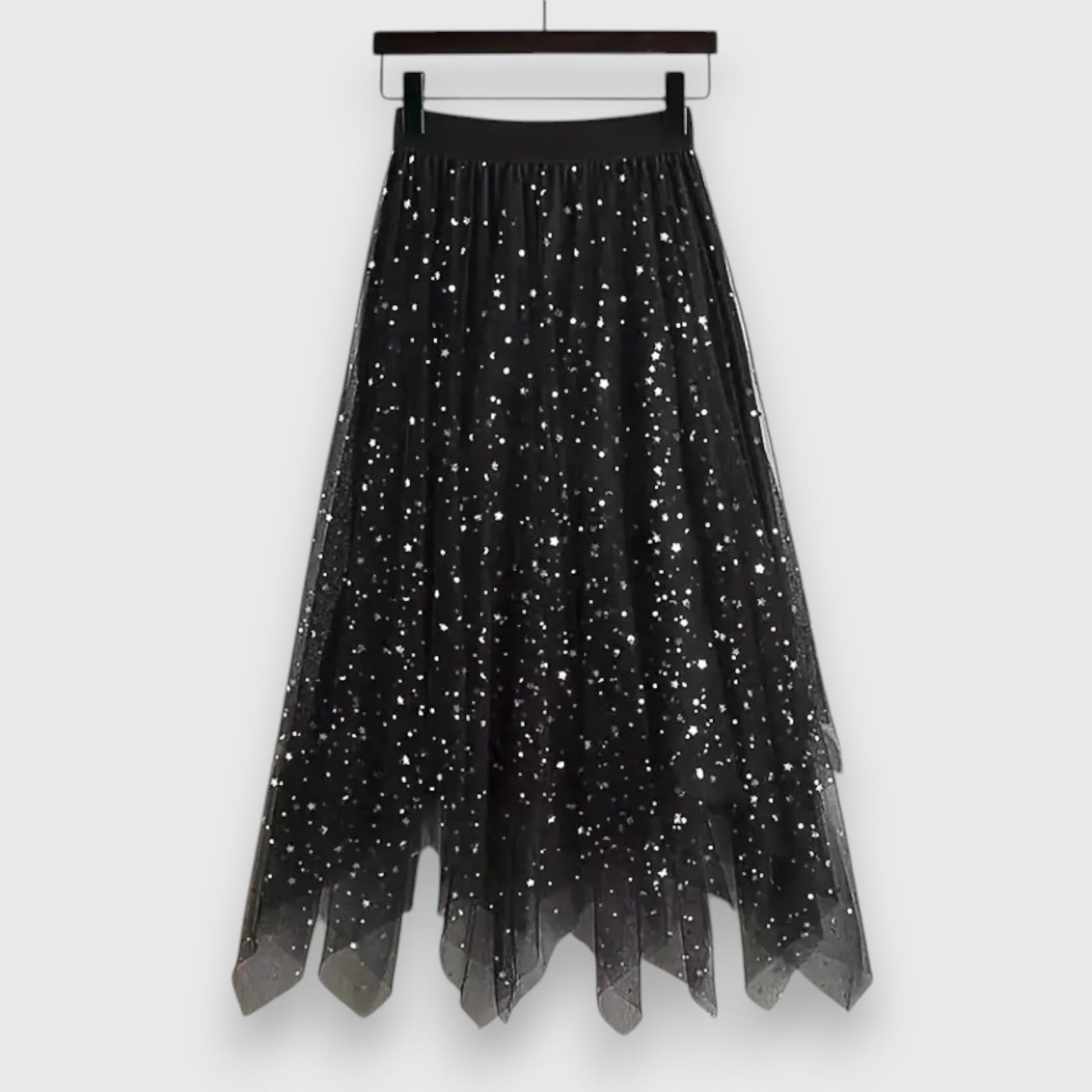 Side view of a woman gracefully walking in the black Valentina tulle midi skirt, highlighting its fluid movement and midi length.